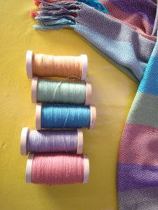 Bobines de fil de laine mérinos pour le tissage d'une écharppe.