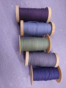 Bobines de fil de laine mérinos pour le tissage d'une écharpe.