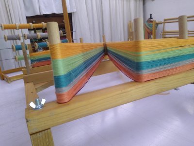 Ourdissage de la chaine de tissage d'une écharppe rayée sur cadre à ourdir.